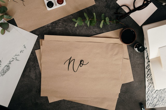 brown paper on desk with the word 'no' hand written on it